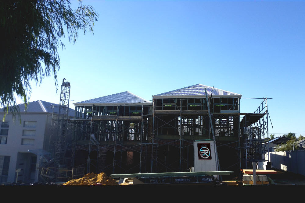 Elevation of new 2 storey house under construction, with scaffolding and walls, with Zincalume roof in place